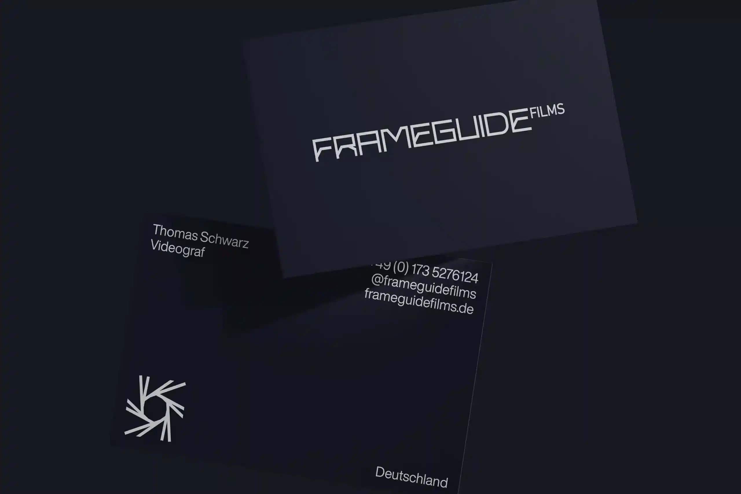 Dunkel gehaltene Visitenkarten des Videoproduktionsstudios Frameguide Films mit modernem, klaren Logo und Kontaktdaten.