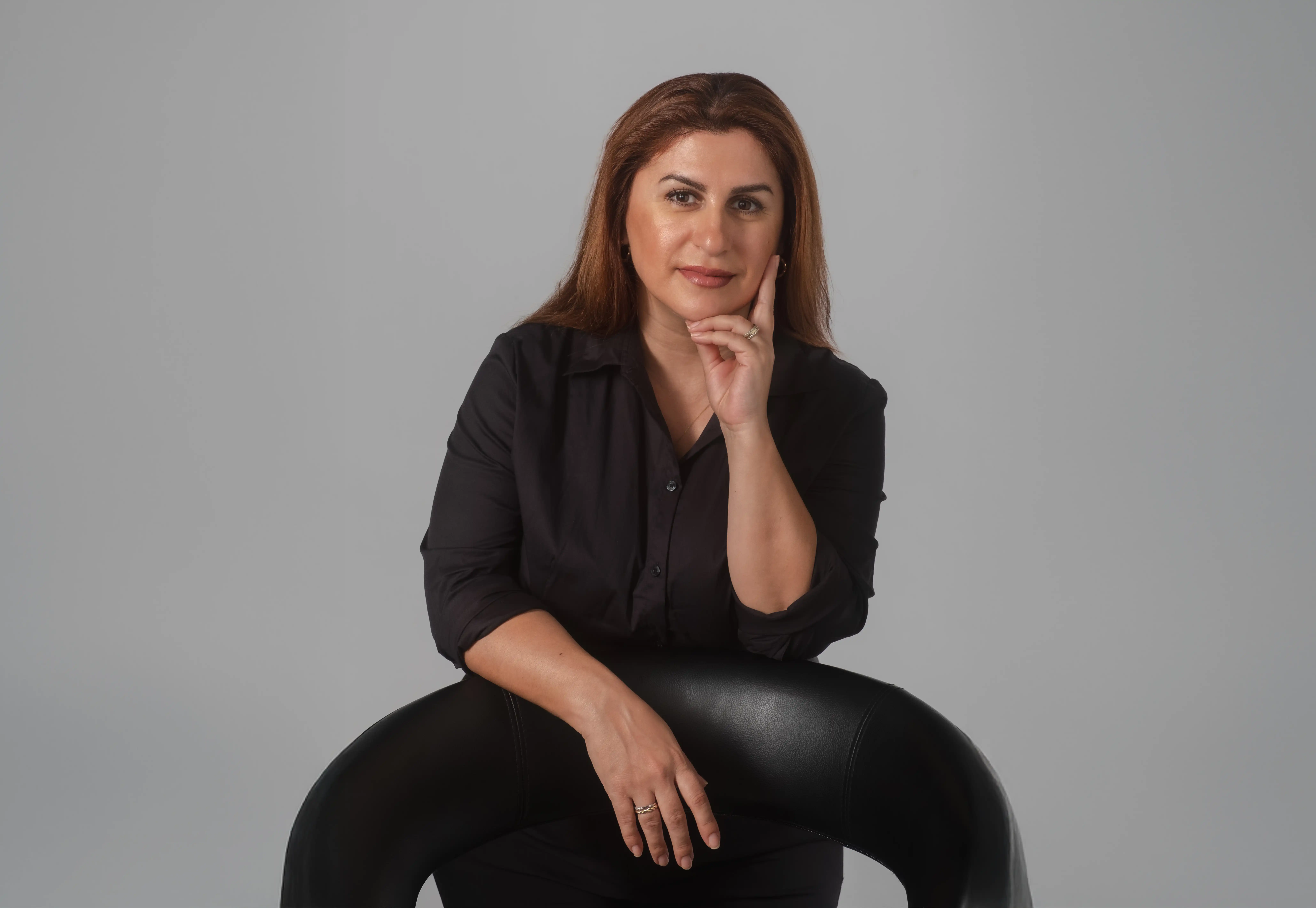 IA-Studio – Branding, Logo Design & Webdesign in Wien Professionelles Portraitfoto einer Frau in schwarzem Outfit, fotografiert für das Branding und Webdesign eines Beauty-Unternehmens.